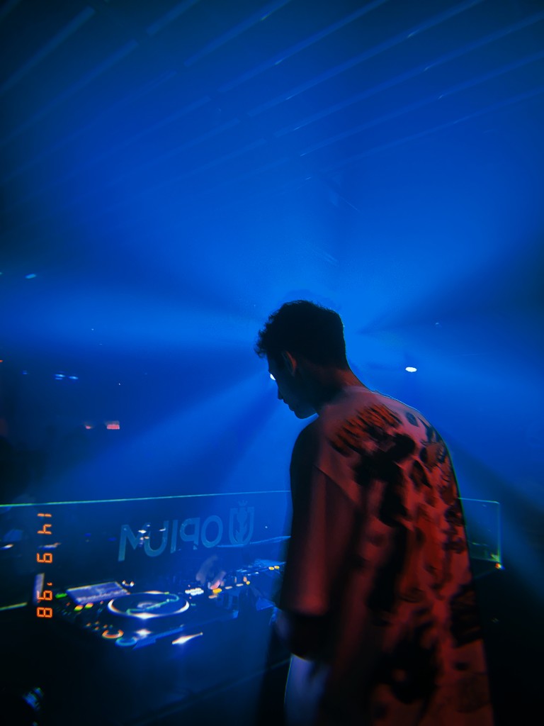 DJ Mion tocando em uma pista iluminada por luz azul